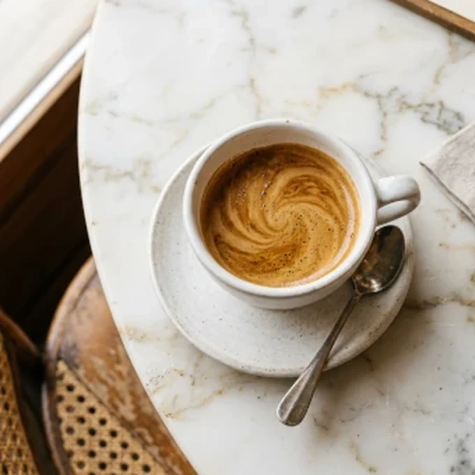 Espresso served on a marble cafe table with background music playing